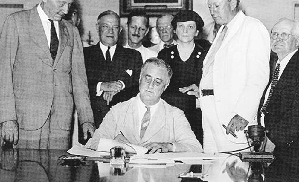 US-Präsident Franklin D. Roosevelt unterzeichnet den Social Security Act, 14. August 1935. Social Security Agency (Internet).