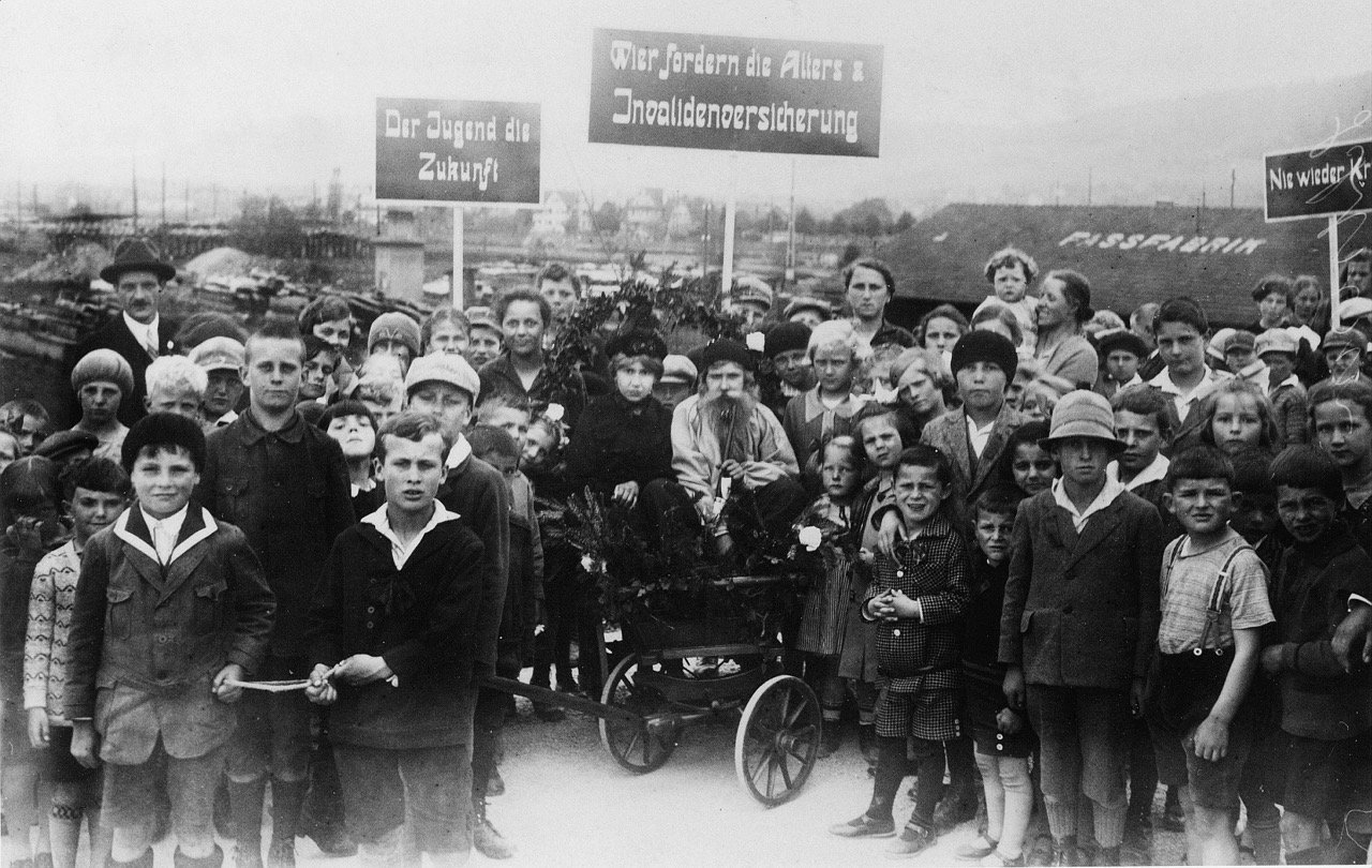 «Wir fordern Alters- und Invalidenversicherung»: 1. Mai-Umzug in Schlieren, vermutlich 1927. Quellennachweis: Schweizerisches Sozialarchiv, Zürich.